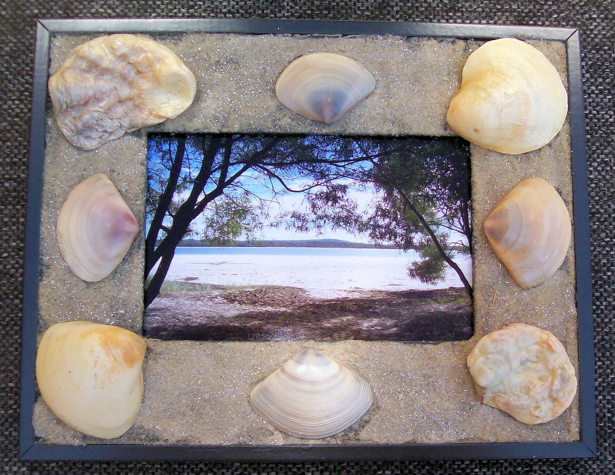 Picture frame with shells and sand glued on it